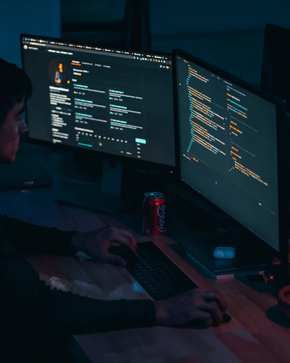 Desarrollador trabajando frente a monitores con código